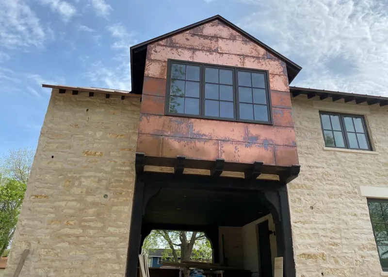 Copper metal panel facade on a stone building for Roof Repair in River Ridge